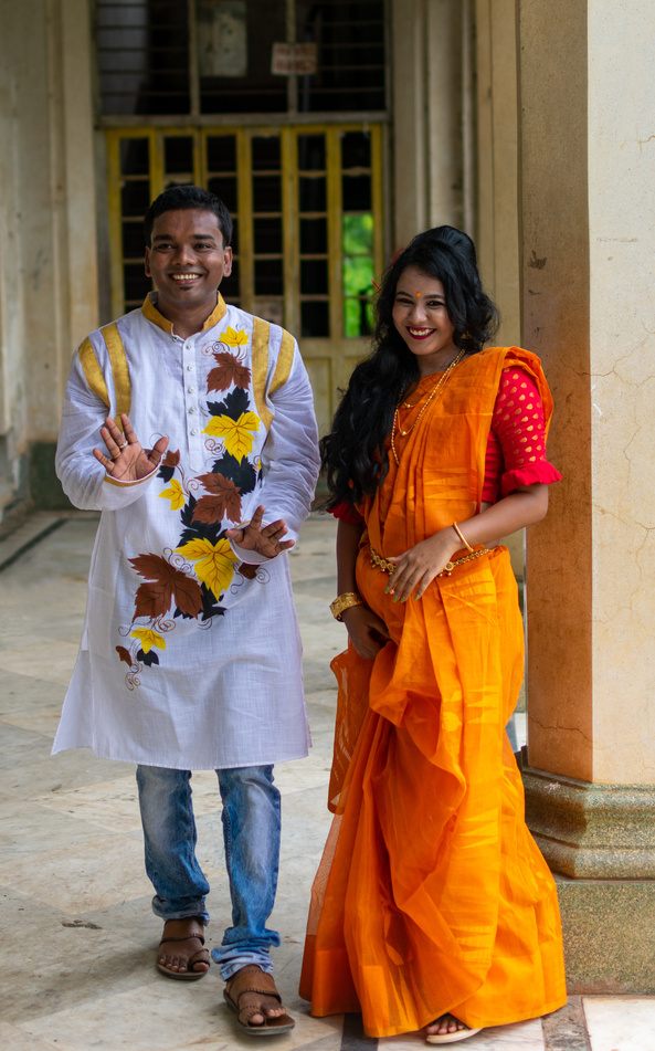 Beautiful Indian couple wearing traditional ethnic clothes (saree and kurta), talking and laughing. Bengali couple in love enjoy a moment of happiness. Selective focus.